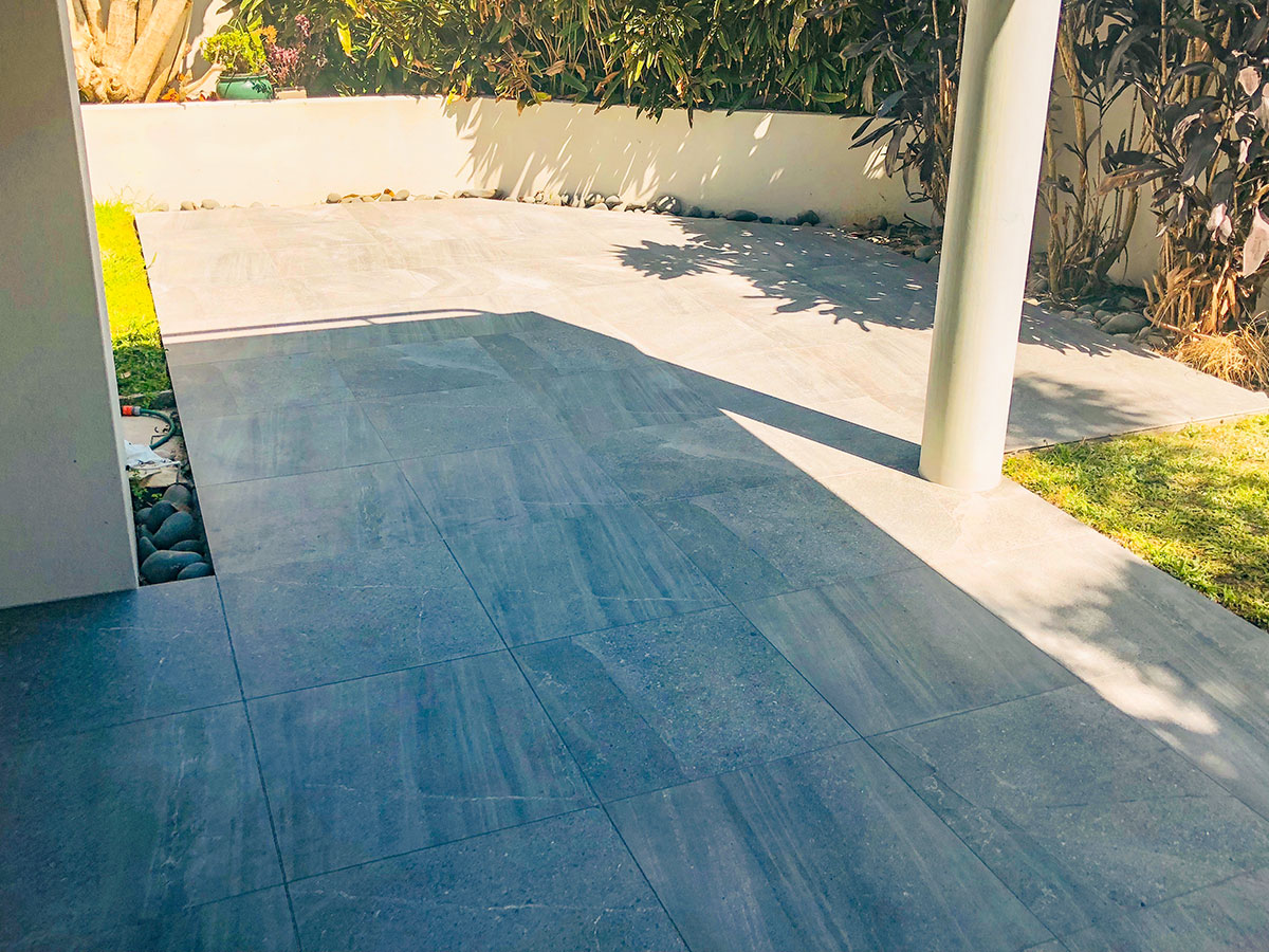 Outdoor tiled patio and pool area in Auckland by Hi Tech Tiling